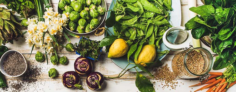 Vegetables and flowers spread across a white wooden table