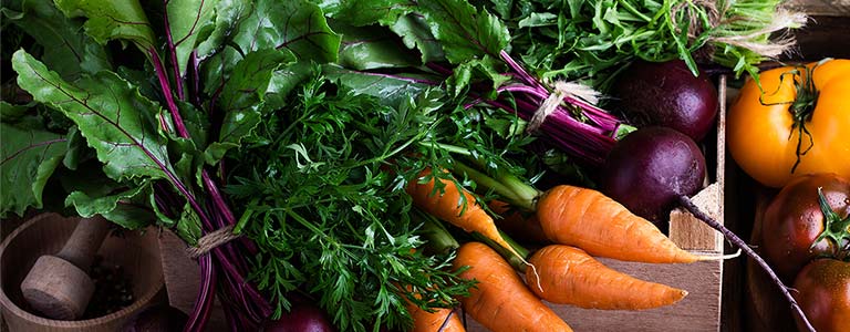 A collage of vibrant, organic vegetables displayed across a table